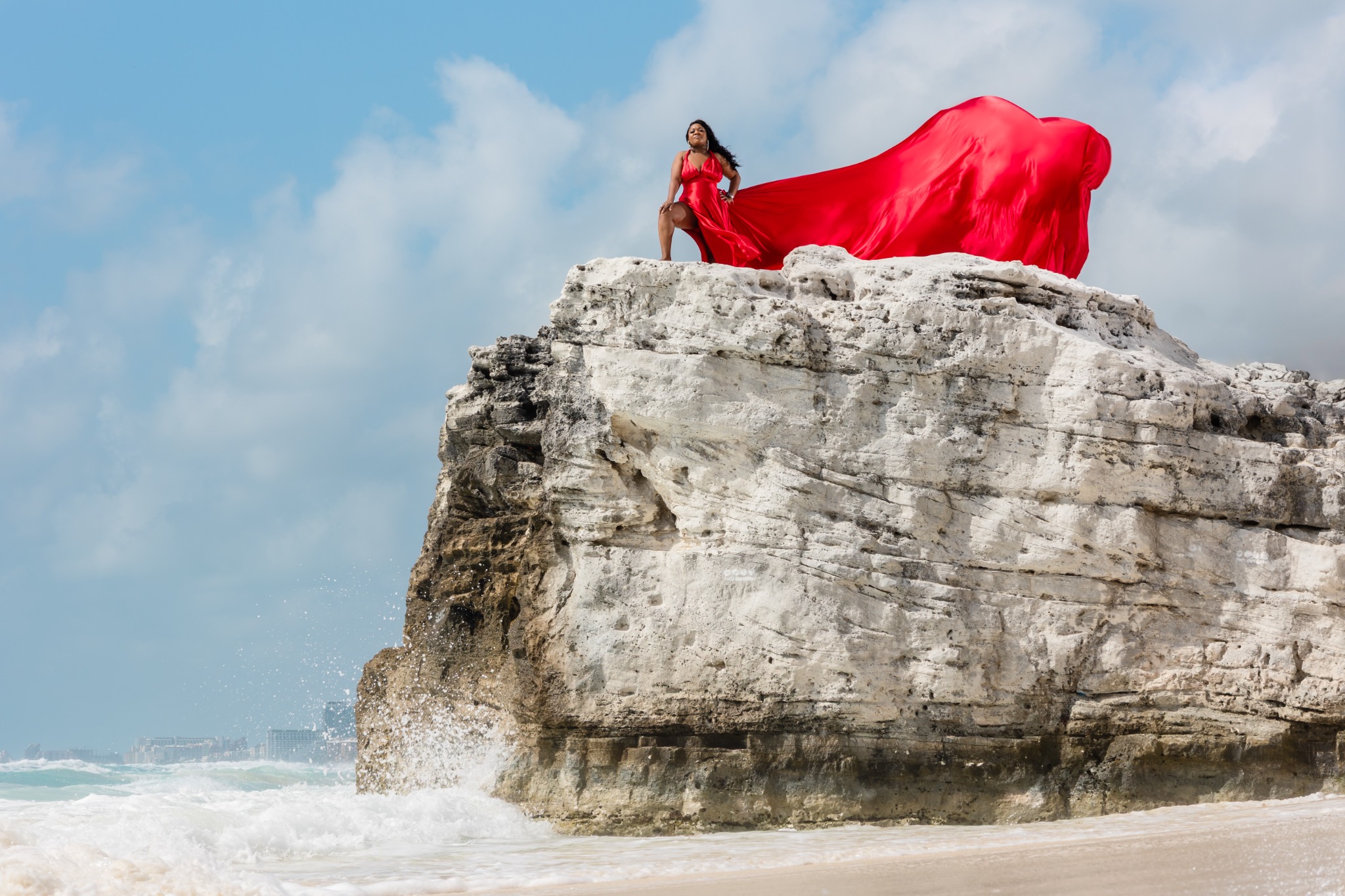 Tonya M. Holmes in a flowing red dress overlooking the ocean